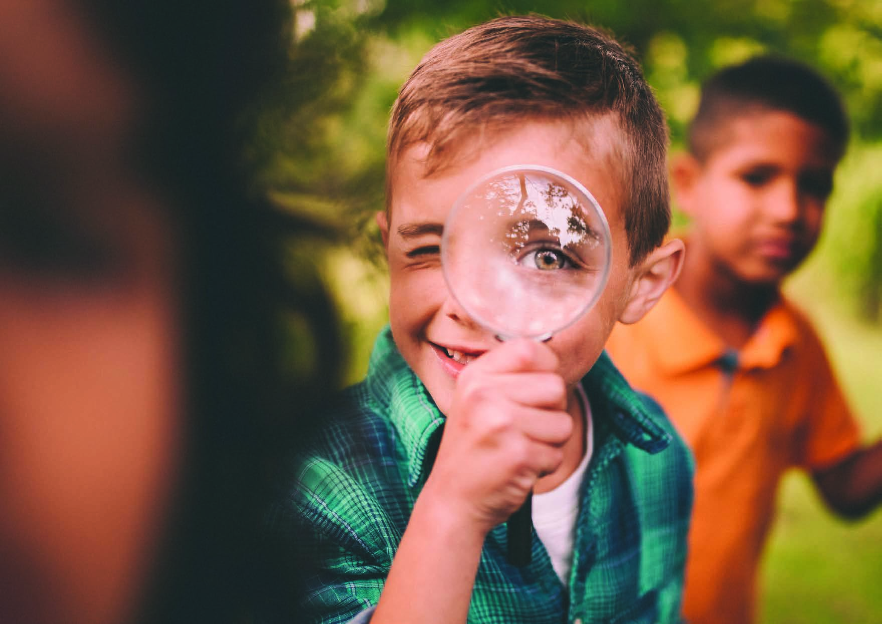 boy looking through magnifying glass