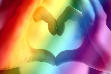 Hands making heart shape overlaid with the colours of the rainbow