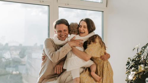 young child hugging smiling parents