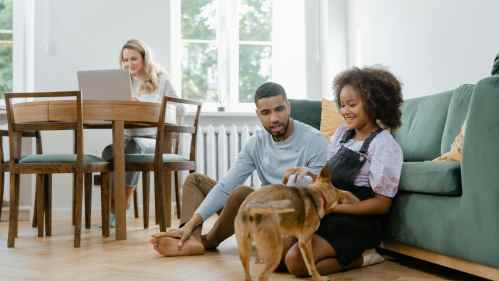Man and girl sitting on floor with pet dog